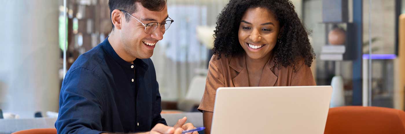 A man and a woman discussing data on a computer.